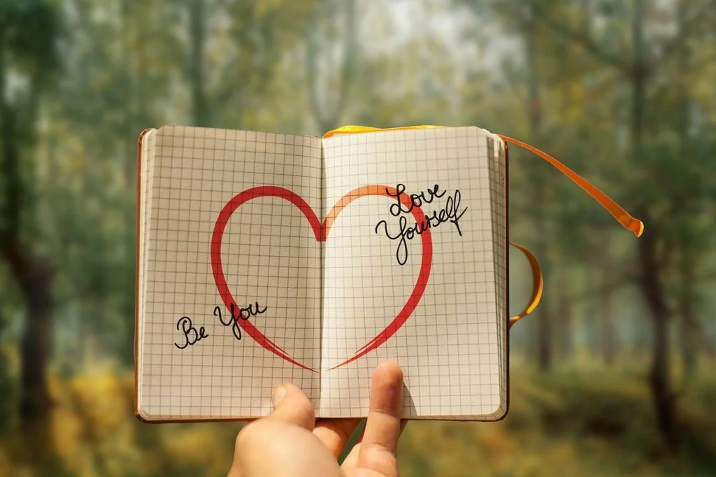 développement personnel cahier avec un coeur dessiné et "être soi" et "s'aimer" écrits