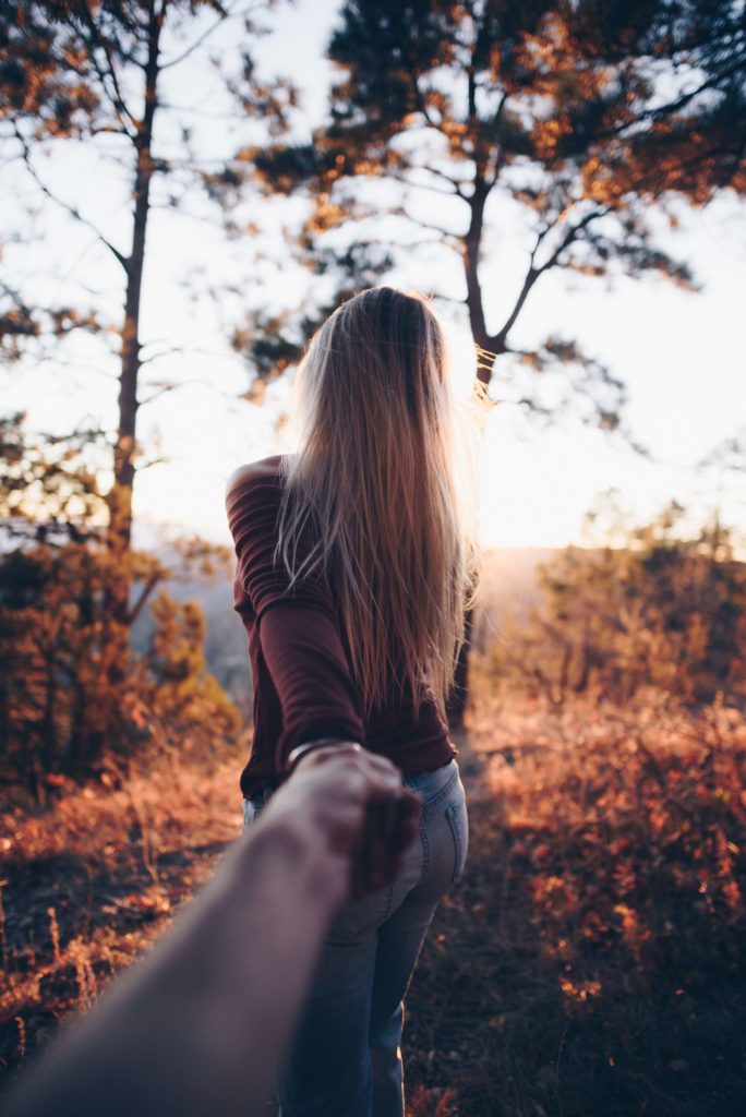 Femme tenant la main de son partenaire en forêt